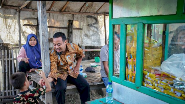Gubernur Sulsel Andi Sudirman Sulaiman, memberikan tusuk bakso kepada salah satu anak warga saat mampir di Kabupaten Takalar, Kamis (25/05/2023). (Istimewa)