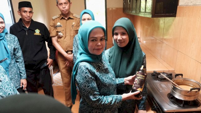 Wakil Ketua Tim Penggerak PKK Kabupaten Gowa Mussadiyah Rauf usai menyaksikan demo pembuatan gula aren cair dengan nama "Gowaren". Produk ini dipromosikan di sela-sela melakukan SMEP TP PKK Kabupaten Gowa, di Desa Buakkang, Kecamatan Bungaya, kemarin. (Dok. Humas Gowa)