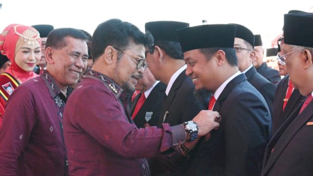 Menteri Pertanian Syahrul Yasin Limpo, memakaikan pin tanda penghargaan kepada Gubernur Sulsel Andi Sudirman Sulaiman. (Istimewa)