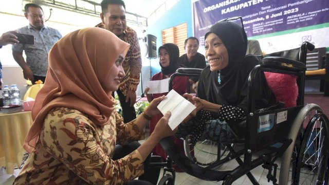 Bupati Luwu Utara Indah Putri Indriani menyerahkan bantuan kepada salah satu disabilitas di Luwu Utara.