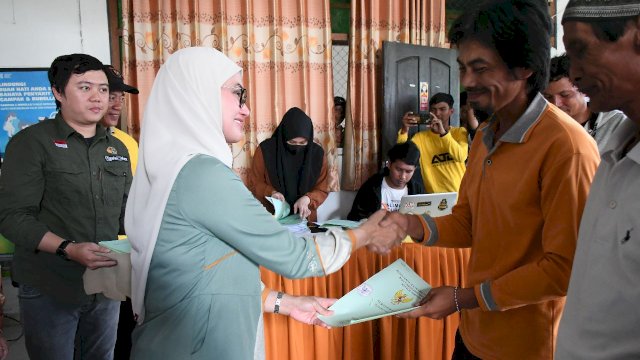 Bupati Luwu Utara Indah Putri Indriani menyerahkan sertifikat tanah kepada salah satu Warga Transmigrasi UPT Buso Desa Sassa. Minggu (25/6/2023)