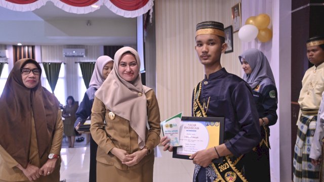 Bupati Luwu Utara Indah Putri Indriani menyerahkan piagam kepada Duta Anak Luwu Utara 2023 terpilih.