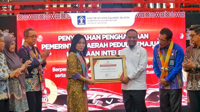 Dirjen KI Min Usihen dan Staf Ahli Menteri Bidang reformasi Birokrasi Asep Kurnia didampingi Kakanwil Kemenkumham Sulsel Liberti Sitinjak saat memberikan penghargaan kepada Gubernur Sulsel Andi Sudirman Sulaiman, di sela-sela Pembukaan Mobile Intellectual Property Clinic atau Klinik Kekayaan Intelektual Bergerak, di Pipo Mall Makassar, kemarin. (Dok. Humas Kanwil Kemenkumham Sulsel)