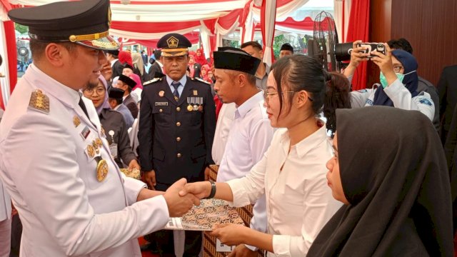 Bupati Gowa Adnan Purichta Ichsan saat memberikan SK remisi kepada salah satu warga binaan Lapas Perempuan Kelas II A Sungguminasa, usai pelaksanaan Upacara Detik-Detik Proklamasi Kemerdekaan RI Ke-78 Tingkat Kabupaten Gowa, di Lapangan Upacara Kantor Bupati Gowa, Kamis (17/08/2023). (Chaerani/Republiknews.co.id)