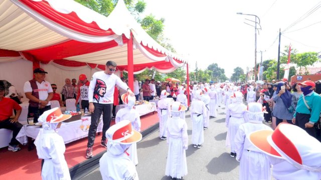 Bupati Gowa Adnan Purichta Ichsan saat menerima salam penghormatan dari salah satu peserta Lomba Gerak Jalan Pelajar dalam rangka HUT Kemerdekaan RI Ke-78 Tingkat Kabupaten Gowa, di Jalan Masjid Raya, Sungguminasa, Minggu (13/08/2023). (Dok. Humas Gowa)