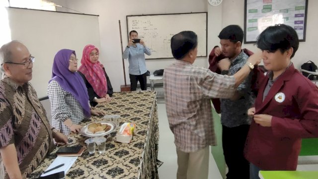 Rektor UCM Prof. M. Tahir Kasnawi, melepas keberangkatan kedua mahasiswa ditandai dengan pemasangan jaket UCM warna merah darah, Rabu (30/08/2023). (Istimewa)