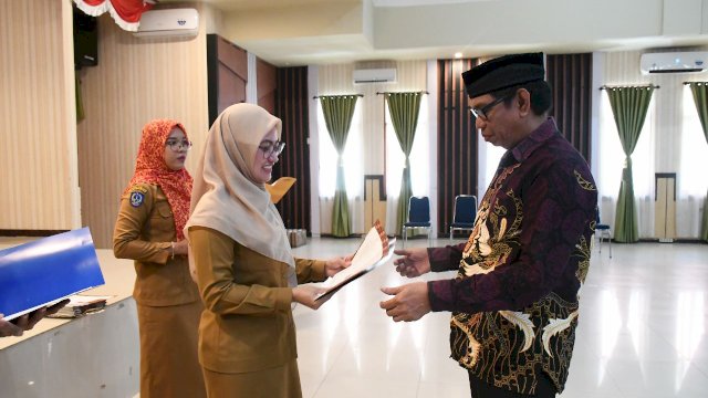 Bupati Luwu Utara Indah Putri Indriani menyerahkan SK pesiun kepada Kepala Dinas Pertanian Luwu Utara Rusdi Rasyid.