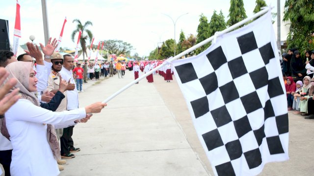 Bupati Luwu Utara mengangkat bendera start tanda dimulainya gerak jalan Indah.