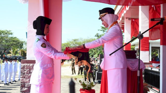 Bupati Luwu Utara Indah Putri Indriani menyerahkan bendera pusaka merahputih kepada paskibraka saat upacara pengibaran bendera memperingati HUT Ke-78 RI.