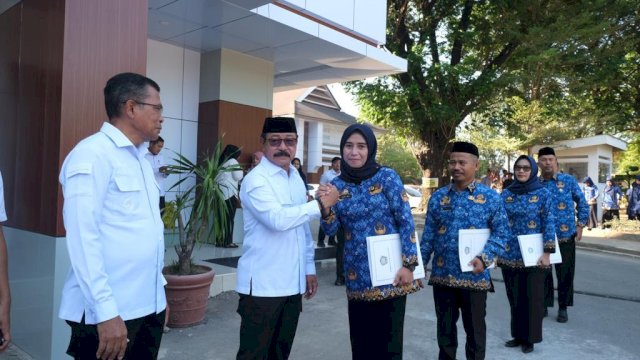 Wakil Bupati Gowa Abd Rauf Malaganni saat menyerahkan SK pengangkatan kepada salah satu PPPK usai Upacara Penyerahan SK PPPK dan Penandatanganan Perjanjian Kerja Formasi Tahun 2022, di Halaman Kantor Bupati Gowa, Rabu (06/09/2023). (Dok. Humas Gowa)