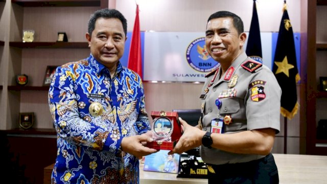 Pj Gubernur Sulsel Bahtiar Baharuddin, menerima cendera mata dari Kepala BNNP Sulsel Brigjen Pol Guruh Ahmad, Jumat (08/09/2023). (Istimewa)