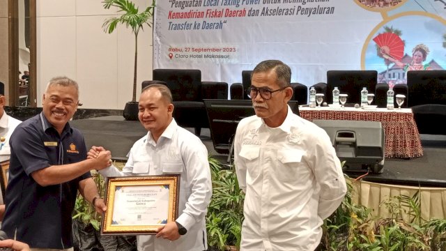 Kepala Badan Pendapatan Daerah Kabupaten Gowa Indra Wahyudi Yusuf mewakili Bupati Gowa Adnan Purichta Ichsan saat menerima penghargaan Pemerintah Daerah dengan Kinerja Pengelolaan Dana Desa Terbaik di Semester 1 Tahun 2023, di sela-sela Desiminasi Kajian Fiskal Regional Sulawesi Selatan, di Hotel Claro Makassar, kemarin. (Dok. Chaerani/Republiknews.co.id)