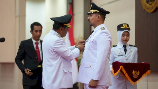 Pj Gubernur Sulsel Bahtiar Baharuddin, memakaikan Gobang tanda jabatan kepada Akbar Andi Laluasa yang dilantik menjadi Wakil Bupati Luwu Timur, Kamis (05/10/2023). (Istimewa)