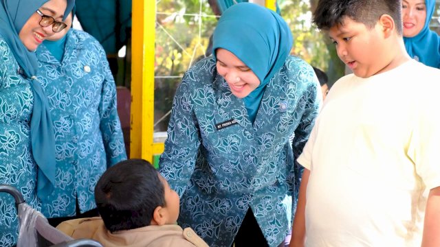 Ketua TP PKK Kabupaten Gowa Priska Pramita Adnan bersama anak keduanya Arya Mahardika Adnan didampingi sejumlah pengurus TP PKK Kabupaten Gowa saat menyerahkan langsung bantuan kursi roda elektrik kepada Reski, di SD Inpres Saluttowa, Desa Parigi, Kecamatan Tinggimoncong, kemarin. (Dok. Humas Gowa)