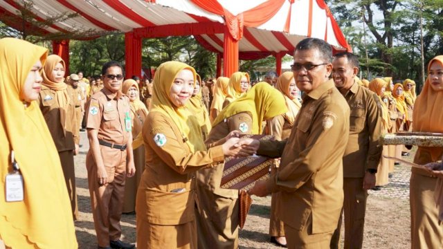 Penjabat (Pj) Sekretaris Daerah Kabupaten Gowa, Abdul Karim Dania menyerahkan penghargaan kepada salah satu tenaga kesehatan di Perayaan HKN 2023, di Lapangan Upacara Kantor Bupati Gowa, Selasa, (12/11/2023). (Dok. Humas Gowa)