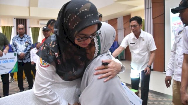 Bupati Luwu Utara, Indah Putri Indriani saat menyerahkan santunan kepada ahli waris pekerja rentan Desa Harapan.