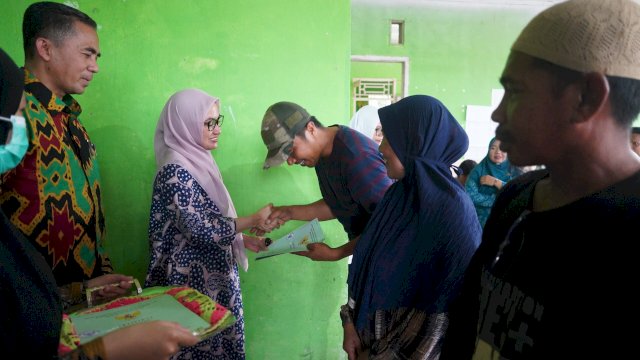 Bupati Luwu Utara Indah Putri Indriani menyerahkan sertifikat kepada salah satu warga Desa Pekendekang Kecamatan Sabbang.