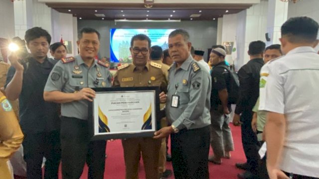 Pj Gubernur Kaltim, Akmal Malik, menyerahkan penghargaan kepada Kalapas Narkotika Samarinda, Hidayat, Selasa (12/12/2023). (Istimewa)