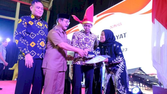 Wakil Bupati Gowa Abd. Rauf Malaganni bersama Wakil Menteri ATR/BPN Raja Juli Antoni (kedua kanan) saat menyerahkan sertifikat tanah kepada salah satu warga Kecamatan Somba Opu melalui Program PTSL, di GOR Sungguminasa, Selasa, (12/12/2023). (Dok. Humas Gowa)