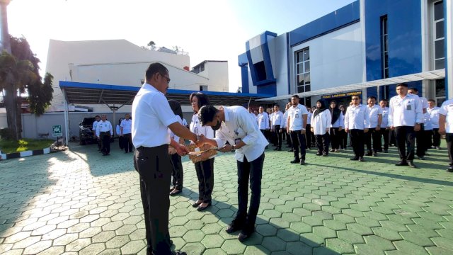 Kakanwil Kemenkumham Sulsel Liberti Sitinjak saat memberikan penghargaan kepada salah satu pegawai teladan, di sela-sela Apel Pagi, di Pelataran Kanwil Kemenkumham Sulsel, Rabu, (27/12/2023). (Dok. Humas Kanwil Kemenkumham Sulsel)