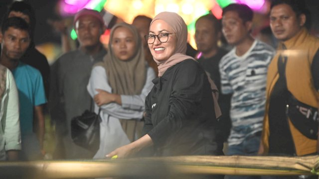 Bupati Luwu Utara Indah Putri Indriani mencoba salah satu permainan (lempar kaleng) yang ada di Masamba Maroa Expo.