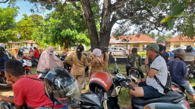 Warga Merauke mencari signal jaringan internet di halaman Kantor Pos Merauke. (Foto: Hendrik Resi / republiknews.co.id)