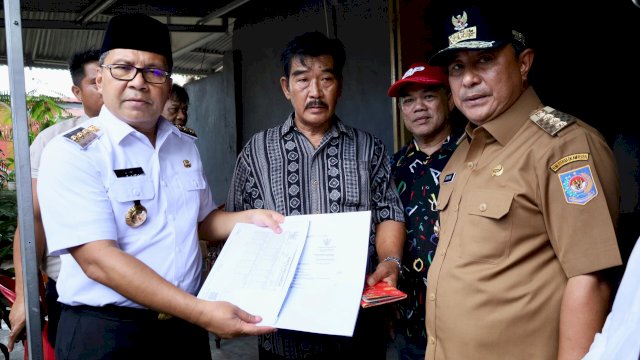 Wali Kota Makassar, Moh Ramdhan Pomanto dan Pj Gubernur Sulsel, Bahtiar Baharuddin saat menyerahkan akta kematian dan KK baru kepada keluarga KPPS yang meninggal dunia di Makassar, Rabu (21/2/2024). (Foto: Istimewa).