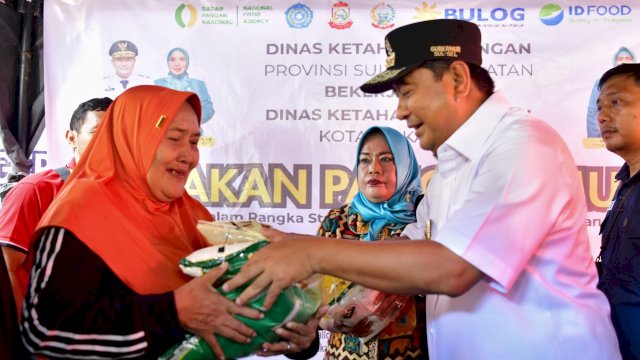 Pj Gubernur Sulsel Bahtiar Baharuddin, menyerahkan bantuan beras dari Pemprov kepada warga kurang mampu di Kawasan Kuliner Lego-lego CPI, Ahad (17/03/2024). (Istimewa)