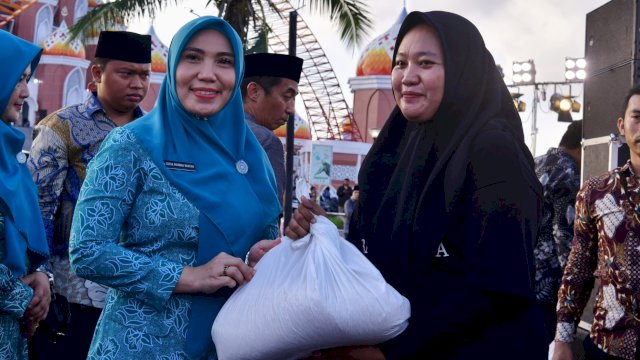 Pj Ketua PKK Sulsel Sofha Marwah Bahtiar, saat menyerahkan paket sembako murah kepada salah satu warga di Pelataran Masjid 99 Kubah Kawasan Lego-Lego CPI Kota Makassar, Ahad (17/03/2024). (Istimewa)