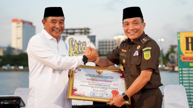 Pj Gubernur Sulsel.Bahtiar Baharuddin, memberikan pagam Penghargaan kepada Leonard Eben Ezer Simanjuntak, atas Dedikasinya selama menjabat Kajati Sulsel, Rabu (20/03/2024). (Istimewa)