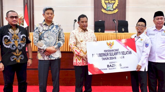 Pj Gubernur Sulsel Bahtiar Baharuddin, saat menyerahkan secara simbolik Zakat, Infak dan Shodaqoh ASN Pemerintah Provinsi Sulsel kepada Baznas Sulsel, Kamis (21/03/2024). (Istimewa)