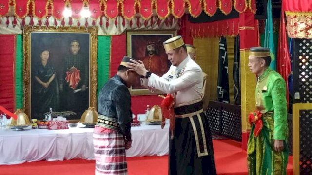 Bupati Gowa Adnan Purichta Ichsan disaksikan Keluarga Kerajaan Gowa saat menyematkan songko guru biring bulaeng kepada Kepala Kejati Sulsel Leonard Eben Ezer Simanjuntak I Manuntungi Daeng Matola usai mendapatkan gelar adat, di Musuem Balla Lompoa, Senin, (25/03/2024). (Dok. Chaerani/Republiknews.co.id)