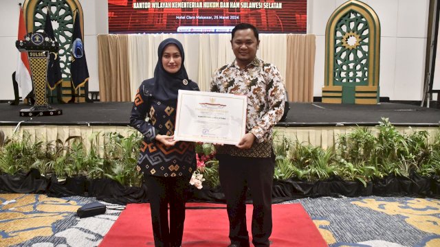 Bupati Luwu Utara Indah Putri Indriani menunjukkan piagam Penghargaan Kabupaten Peduli HAM. (ist)