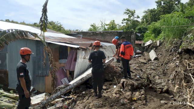 Ket : Tim BPBD Parepare melakukan evakuasi tembok Pembatas SMP 3 Parepare yang roboh menimpa rumah warga 