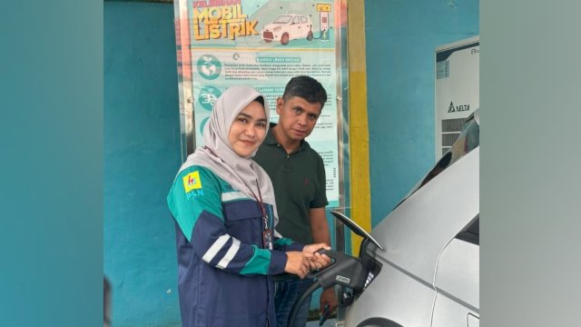 Manager PLN UP3 Palopo, Rathy Shinta Utami (kiri), tengah mendampingi pemilik mobil listrik, Azis saat melakukan pengisian daya di SPKLU PLN UP3 Palopo. (Istimewa)