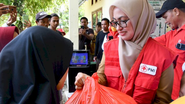 Ketua PMI Luwu Utara Indah Putri Indriani menyerahkan bantuan kepada salah satu warga Kecamatan Bone-bone. Selasa (02/04/2024)