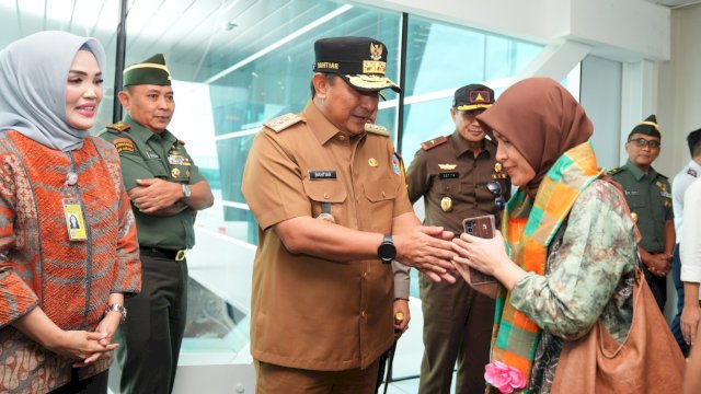 Pj Gubernur Sulsel Bahtiar Baharuddin, menyalami salah satu penumpang saat pembukaan rute penerbangan Makassar - Banjarmasin, Rabu (03/04/2024). (Istimewa)