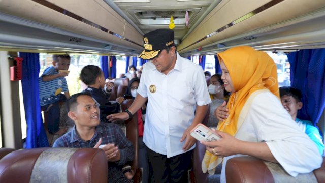 Pj Gubernur Sulsel Bahtiar Baharuddin, berbincang dengan salah satu peserta mudik gratis, Sabtu (06/04/2024). (Istimewa)