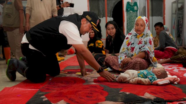 Pj Gubernur Sulsel Bahtiar Baharuddin, saat memastikan kondisi bayi korban banjir bandang di di Desa Cimpu dan Cimpu Utara, Kecamatan Suli, Sabtu dini hari (04/05/2024). (Istimewa)