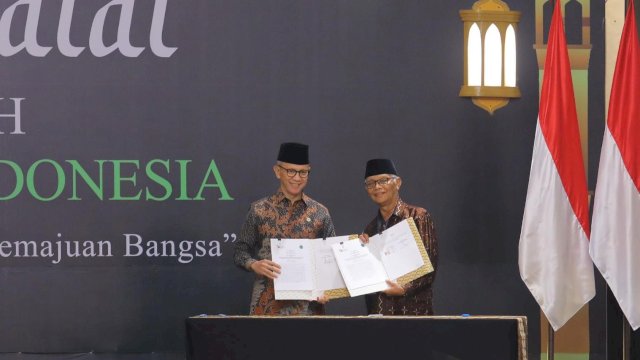 Ketua Dewan Komisioner OJK Mahendra Siregar (kiri), dan Ketua MUI K.H. M. Anwar Iskandar saat melakukan penandatanganan kerjasama, di sela-sela Silaturahmi Kebangsaan dan Halal Bi Halal Idul Fitri 1445 H, kemarin. (Dok. Humas OJK)