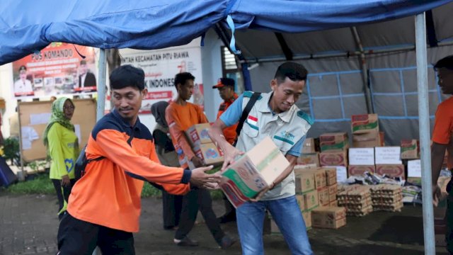 Relawan YBM PLN UP3 Parepare, Avif (kanan) tengah membantu dalam mobilisasi bantuan bencana banjir di Kabupaten Sidrap. (Istimewa)