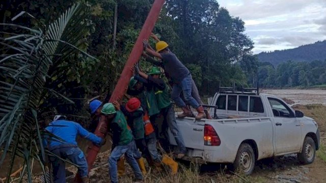 Tim PLN berupaya mendirikan tiang di Desa Poringan, Kabupaten Luwu. (Istimewa)