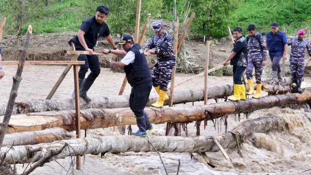 Pj Gubernur Sulsel Bahtiar Baharuddin, melewati batang pohon menyebrang sungai untuk menemui warga terdampak banjir dan tanah longsor yang terisolir di Kecamatan Latimojong, Kabupaten Luwu, Kamis (09/05/2024). (Istimewa)