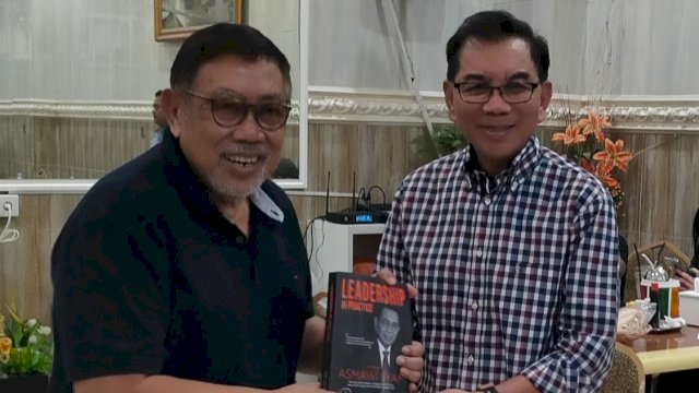 Asmawi Syam menyerahkan buku kepada Prof. Idrus A. Paturusi. (Foto: M. Dahlan Abubakar)