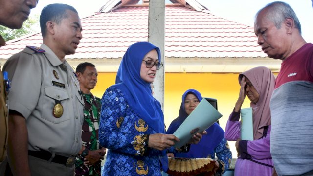 Bupati Luwu Utara Indah Putri Indriani saat menyerahkan sertifikat tanah program PTSL kepada masyarakat Kelurahan Baliase. (ist)
