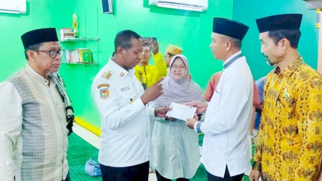 Pj. Gubernur Papua Selatan Apolo Safanpo, memberikan dana pembinaan kepada Juara 1 pemenang Lomba Gema Takbir Keliling Idul Fitri 1445 Hijriyah Masjid Babussalam. (Istimewa)