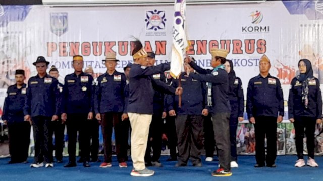Penyerahan bendera pataka Panji Kosti dari Ketua Umum Kosti, Purnomo S. Rahardjo (kiri) kepada Ketua Kosti Papua Selatan, Warto (kanan) di Aula Kanol Sai RRI Merauke. (Foto: Hendrik Republik / Republiknews.co.id)