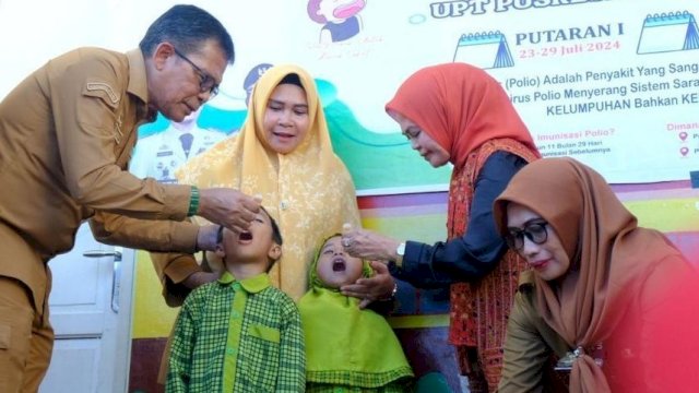 Pj Sekretaris Daerah Kabupaten Gowa Abdul Karim Dania (kiri) bersama Wakil Ketua Tim Penggerak PKK Kabupaten Gowa, Mussadiyah Rauf (kedua kanan) saat memberikan imunisasi polio kepada anak, di sela-sela Pencanangan Pekan Imunisasi Nasional (PIN) Polio Tahun 2024, di TK Al-Muhajirin, Kelurahan Kalegowa, Kecamatan Somba Opu, Selasa (23/07/2024). (Dok. Humas Gowa)