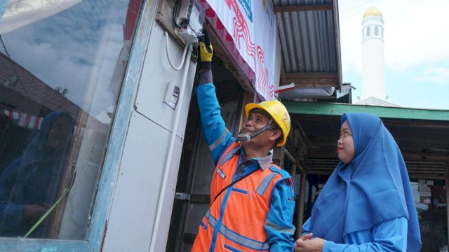 Rona bahagia terpancar dari wajah Jumaidah (kanan) penerima manfaat program Light Up The Dream di Kecamatan Gandus, Palembang oleh petugas PLN. (Istimewa)