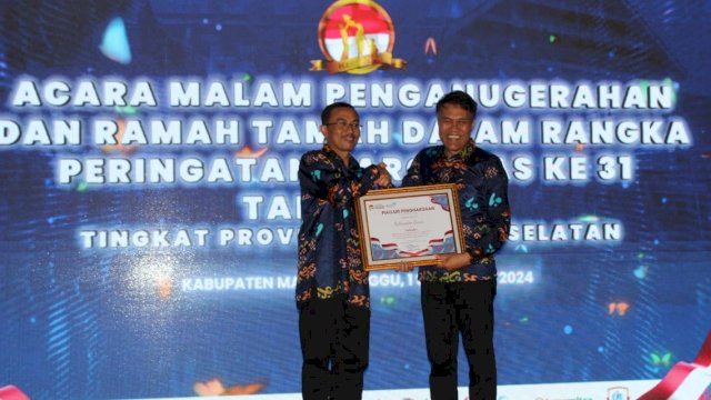 Kepala Dinas PPKB Kabupaten Gowa Sofyan Daud (kanan) saat menerima penghargaan di Peringatan Hari Keluarga Nasional (Harganas) Tingkat Provinsi Sulawesi Selatan, belum lama ini. (Dok. Humas Gowa)